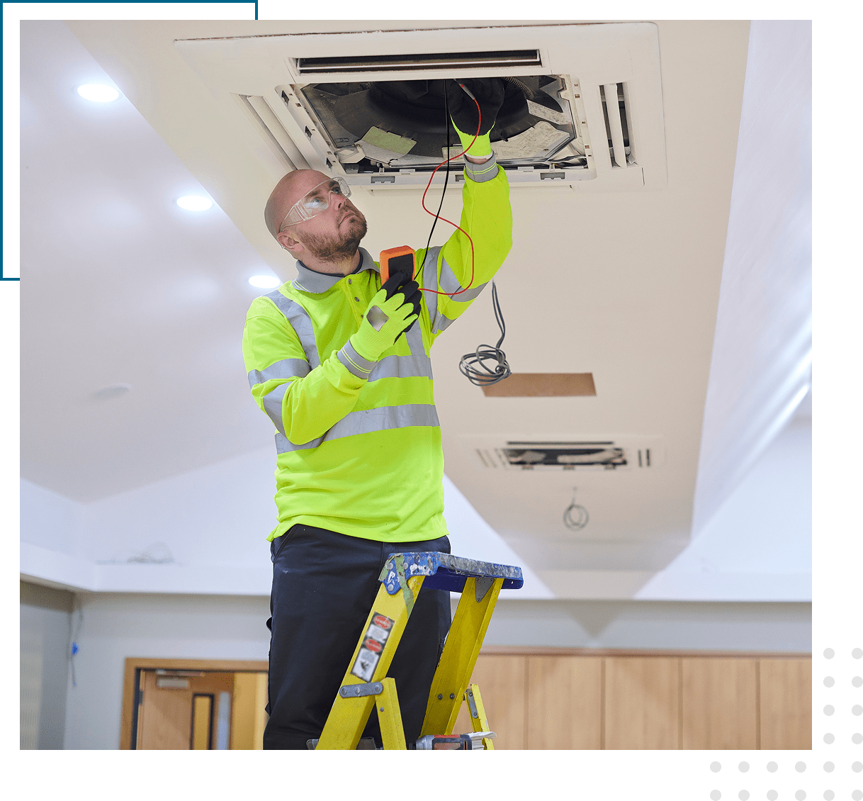 Electrician inspecting ceiling air conditioning unit.