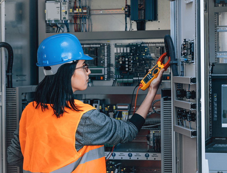 Engineer checking electrical panel with multimeter.