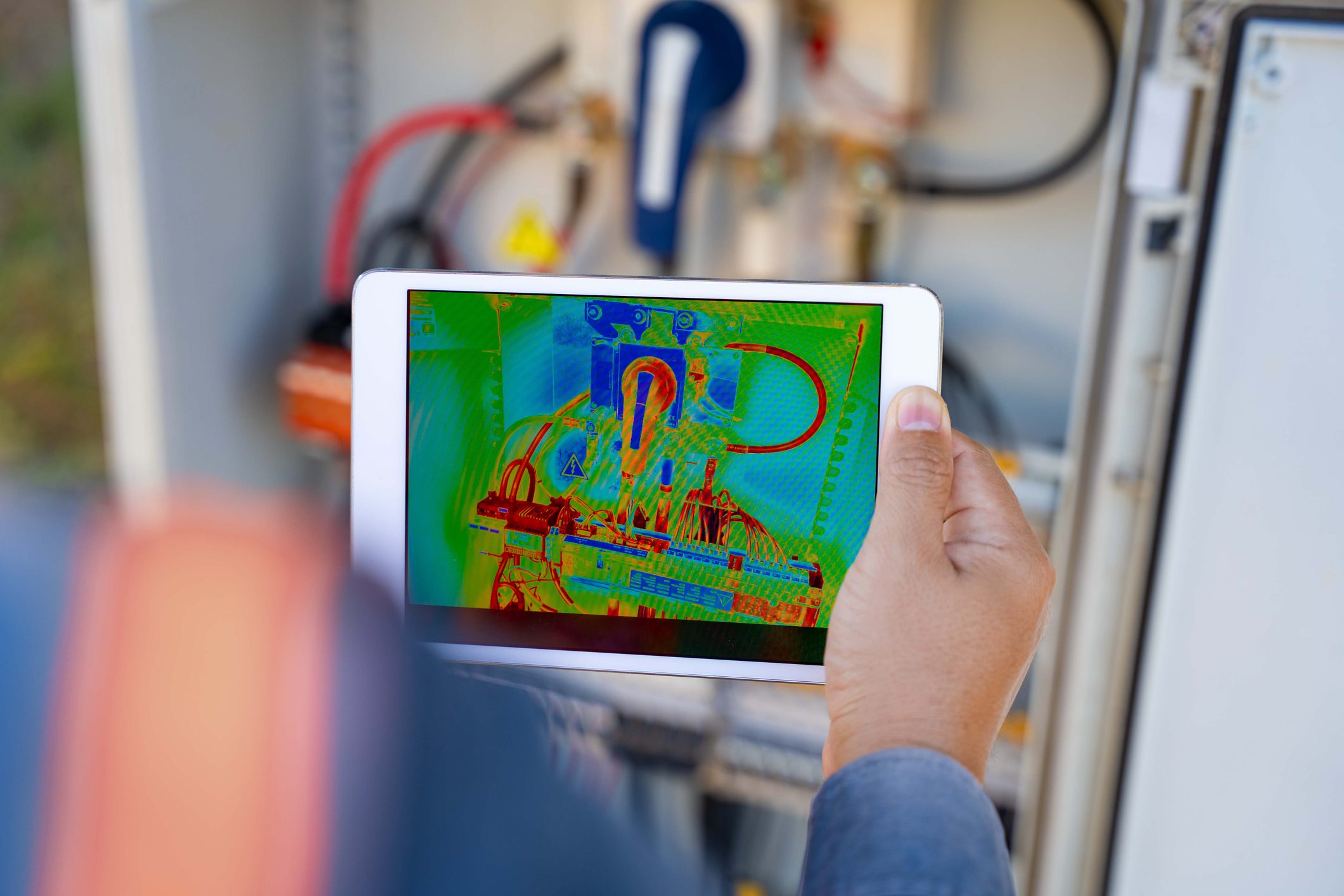 Tablet displaying thermal image near equipment.